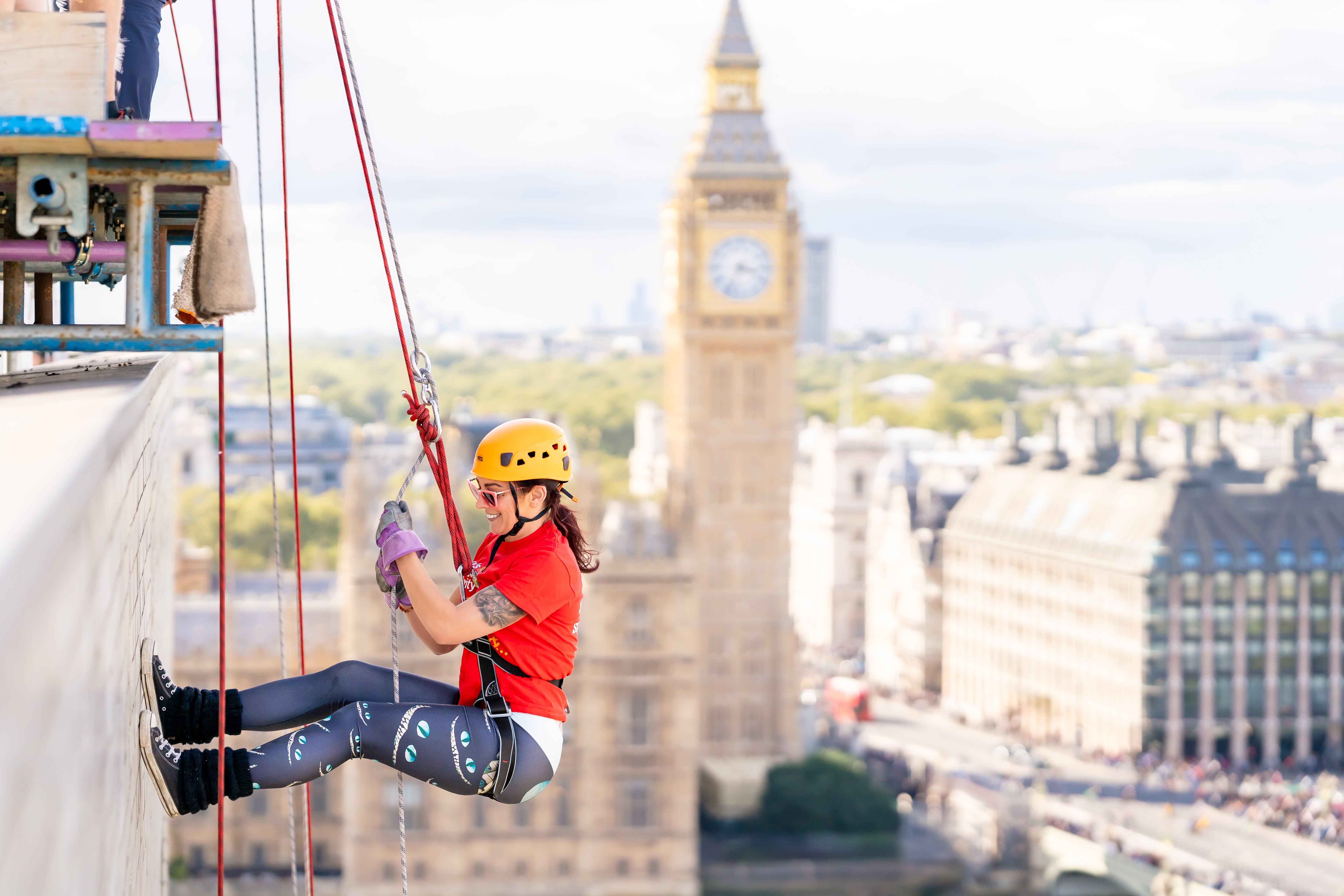 Woman rappelling down London high-rise building