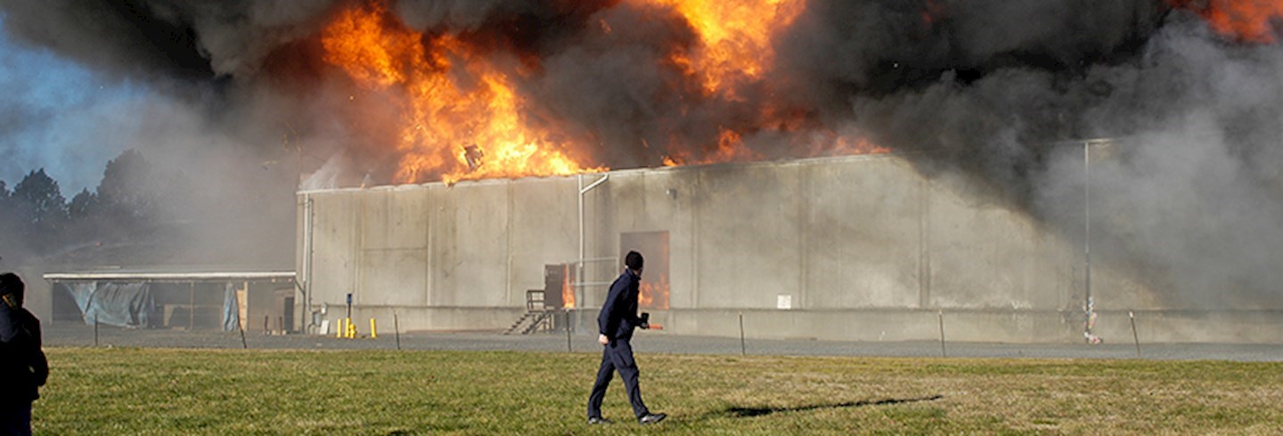 Man observing fire behind wall